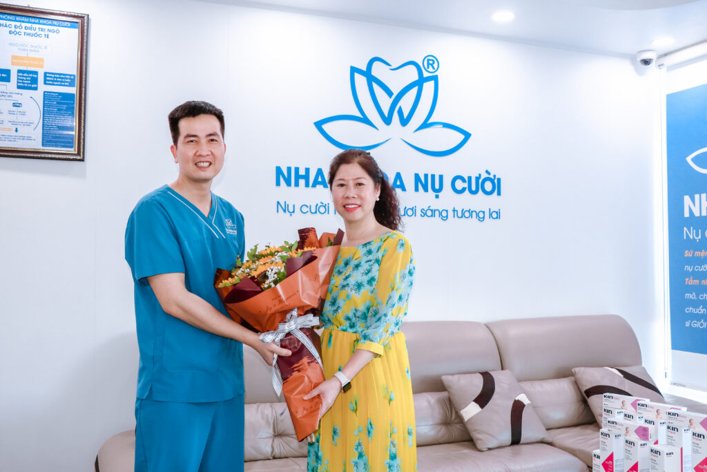 Giám đốc trung tâm - ThS, BS Bùi Việt Hòa tặng hoa cho khách hàng thẩm mỹ răng sứ